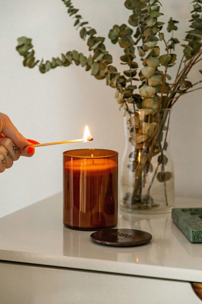 candela profumata con contenitore in vetro marrone